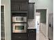 Modern kitchen features stainless steel appliances, dark cabinets, white quartz countertops, and convenient pantry access at 29042 Rivergate Run, Wesley Chapel, FL 33543