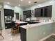 Modern kitchen boasts stainless steel appliances, dark cabinets, white quartz countertops, and a stylish island with seating at 29042 Rivergate Run, Wesley Chapel, FL 33543
