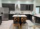 Modern kitchen boasts stainless steel appliances, dark cabinets, white quartz countertops, and a stylish island with seating at 29042 Rivergate Run, Wesley Chapel, FL 33543