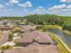 Scenic aerial view of lakeside homes boasts lush greenery, and screened-in lanais on a sunny day at 30327 Lettingwell Cir, Wesley Chapel, FL 33543