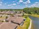 A neighborhood situated by a serene lake with homes featuring screened lanais and neatly manicured lawns at 30327 Lettingwell Cir, Wesley Chapel, FL 33543