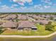 Aerial view of homes by a lake showing screened lanais, lush lawns and backyard patios at 30327 Lettingwell Cir, Wesley Chapel, FL 33543