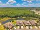 Aerial view featuring a tranquil lake and surrounding homes nestled within a lush green landscape at 30327 Lettingwell Cir, Wesley Chapel, FL 33543