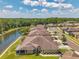 Beautiful aerial view of lakeside homes featuring screened lanais and well-maintained lawns on a sunny day at 30327 Lettingwell Cir, Wesley Chapel, FL 33543