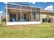 Outdoor living with a covered patio, lush lawn, and a serene backyard at 30327 Lettingwell Cir, Wesley Chapel, FL 33543
