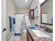 Bathroom with granite countertop, dark wood vanity, shower with decorative curtain, and neutral wall color at 30327 Lettingwell Cir, Wesley Chapel, FL 33543