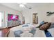 Bedroom showcasing dark hardwood floors, a stylish TV stand and comfortable furniture at 30327 Lettingwell Cir, Wesley Chapel, FL 33543