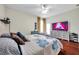 Bright bedroom with hardwood floors, TV, and modern decor at 30327 Lettingwell Cir, Wesley Chapel, FL 33543