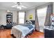 Sunlit bedroom with hardwood floors, ceiling fan, and cheerful, colorful window coverings at 30327 Lettingwell Cir, Wesley Chapel, FL 33543