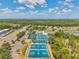 Aerial view showcasing community amenities: pool, tennis and basketball courts, playground, and lake at 30327 Lettingwell Cir, Wesley Chapel, FL 33543