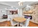 Elegant dining room features a stone accent wall with a fireplace and hardwood floors, open to the kitchen at 30327 Lettingwell Cir, Wesley Chapel, FL 33543