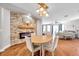 Elegant dining room features a stone accent wall with a fireplace, hardwood floors, and a modern chandelier at 30327 Lettingwell Cir, Wesley Chapel, FL 33543