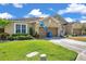 Exterior view of home with green lawn, landscaping, driveway, and attached garages at 30327 Lettingwell Cir, Wesley Chapel, FL 33543