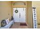 Inviting double front doors, bench with decorative pillows, and HOME sign on brick porch at 30327 Lettingwell Cir, Wesley Chapel, FL 33543