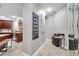 Hallway leading to kitchen with a decorative picture collage on the wall and tiled floors at 30327 Lettingwell Cir, Wesley Chapel, FL 33543