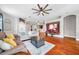 Open-concept living room features hardwood floors, fireplace, and a view into the kitchen and dining area at 30327 Lettingwell Cir, Wesley Chapel, FL 33543