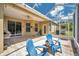 Enclosed patio with tiled floors, ceiling fan, and comfortable seating, perfect for outdoor entertaining at 30327 Lettingwell Cir, Wesley Chapel, FL 33543