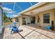 Screened in patio with two chairs, ceiling fan, grill and access to the backyard at 30327 Lettingwell Cir, Wesley Chapel, FL 33543