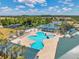 Aerial view of the community pool, playground, and tennis courts on a sunny day at 30327 Lettingwell Cir, Wesley Chapel, FL 33543