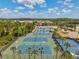 Aerial view of the community tennis courts, well-maintained and surrounded by palm trees at 30327 Lettingwell Cir, Wesley Chapel, FL 33543
