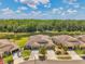Aerial shot of well-maintained townhomes with garages and manicured lawns near a lake at 30327 Lettingwell Cir, Wesley Chapel, FL 33543