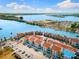 Aerial view of waterfront condos with a view of a marina, bay and bridge in the distance on a clear day at 337 Rex Pl # G, Madeira Beach, FL 33708