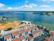 Aerial view of white condos near a baseball field and waterfront with a view of the city skyline and ocean at 337 Rex Pl # G, Madeira Beach, FL 33708