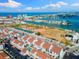 Aerial view of white condos near a baseball field and waterfront with a view of the city skyline and ocean at 337 Rex Pl # G, Madeira Beach, FL 33708