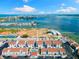 Aerial view of white condos near a baseball field and waterfront with a view of the city skyline and ocean at 337 Rex Pl # G, Madeira Beach, FL 33708