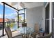 Enclosed balcony with a table and chairs, and view of the pool and palm trees at 337 Rex Pl # G, Madeira Beach, FL 33708