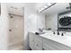 Modern bathroom featuring a white vanity with dual sinks and a tiled walk-in shower at 337 Rex Pl # G, Madeira Beach, FL 33708