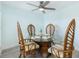 Dining area with a glass-top table, rattan chairs, a ceiling fan, and plenty of natural light at 337 Rex Pl # G, Madeira Beach, FL 33708