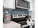 This modern kitchen features stainless steel appliances and a stylish blue tile backsplash at 337 Rex Pl # G, Madeira Beach, FL 33708