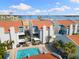 Aerial view of a community pool and white condos with blue trim on a sunny day at 337 Rex Pl # G, Madeira Beach, FL 33708