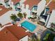 Aerial view of a community pool surrounded by condos, palm trees and patio furniture at 337 Rex Pl # G, Madeira Beach, FL 33708