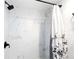 Newly remodeled shower with white marble-style tiles and a modern black shower head at 337 Rex Pl # G, Madeira Beach, FL 33708