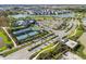 Aerial view of a Primary-planned community featuring a clubhouse, tennis courts, and scenic pond at 34084 Torrent Ln, Wesley Chapel, FL 33543