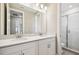 A modern bathroom with double sink vanity, quartz countertop, and glass-enclosed shower at 34084 Torrent Ln, Wesley Chapel, FL 33543