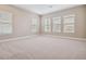 Large bedroom featuring three large windows and neutral colored carpet at 34084 Torrent Ln, Wesley Chapel, FL 33543