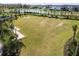 Lush green common area by a pond with palm trees, offering a serene space for residents at 34084 Torrent Ln, Wesley Chapel, FL 33543