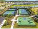 Aerial view of tennis and basketball courts with sidewalks, surrounded by trees and manicured landscaping at 34084 Torrent Ln, Wesley Chapel, FL 33543