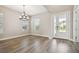 Inviting dining room with stylish lighting, wood floors, and a view of the front yard at 34084 Torrent Ln, Wesley Chapel, FL 33543