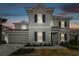 Two-story home featuring a two-car garage, stone accents, and manicured landscaping at 34084 Torrent Ln, Wesley Chapel, FL 33543
