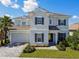 Beautiful two-story home featuring manicured lawn, neutral exterior, and paver driveway at 34084 Torrent Ln, Wesley Chapel, FL 33543