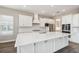 Modern kitchen with white cabinets, center island, stainless appliances, and hexagon backsplash at 34084 Torrent Ln, Wesley Chapel, FL 33543