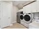 Well-equipped laundry room with stainless steel appliances and ample storage cabinets at 34084 Torrent Ln, Wesley Chapel, FL 33543