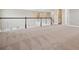 A carpeted loft with a white and wood banister at 34084 Torrent Ln, Wesley Chapel, FL 33543