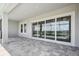 An open patio, featuring brick flooring and wide sliding glass doors to the interior at 34084 Torrent Ln, Wesley Chapel, FL 33543