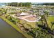Aerial view of a shaded playground area with slides and swings, nestled by a tranquil pond at 34084 Torrent Ln, Wesley Chapel, FL 33543