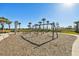 Community playground area featuring swings, a bench, and scenic views, surrounded by palm trees at 34084 Torrent Ln, Wesley Chapel, FL 33543